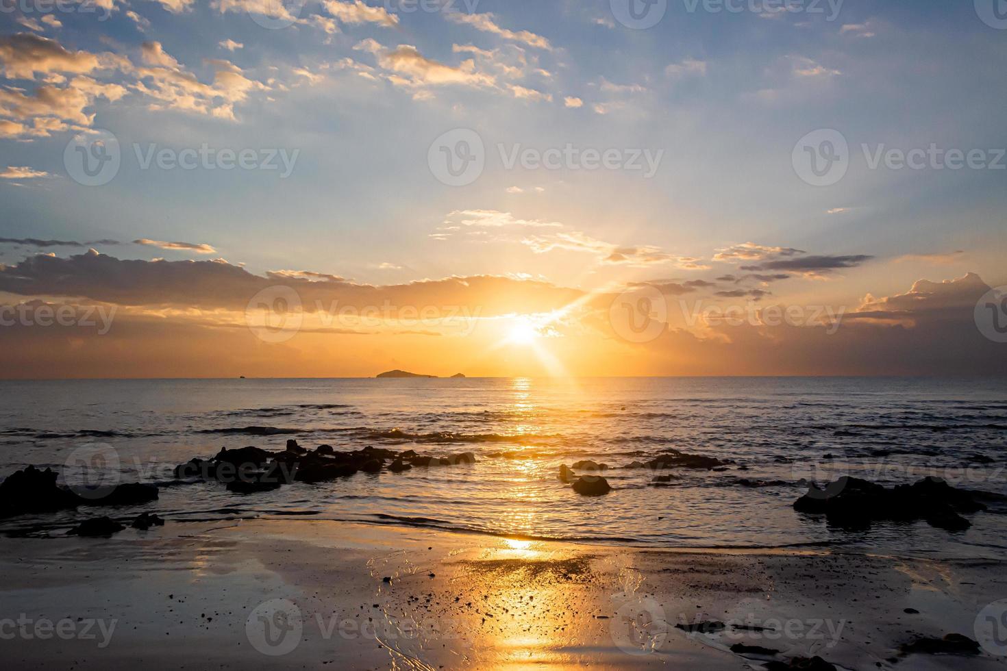 paisaje de puesta de sol en las rocas de la playa en primer plano foto