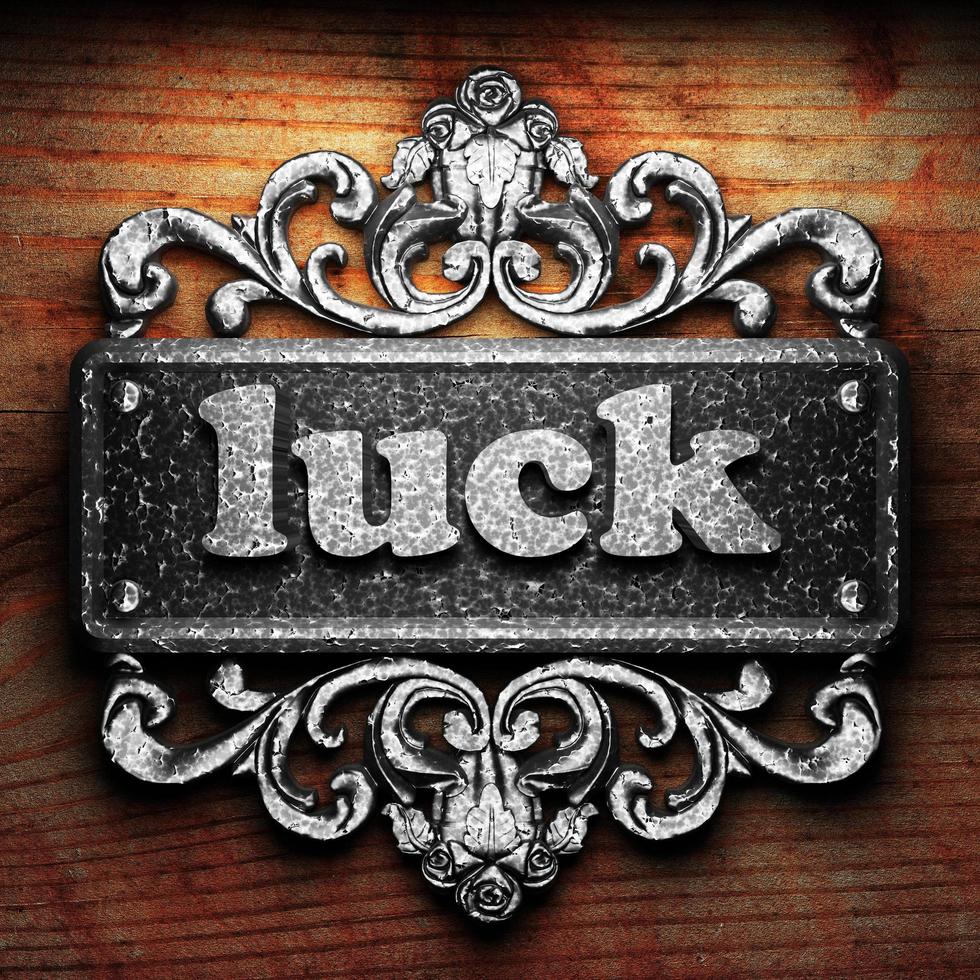 luck word of iron on wooden background photo