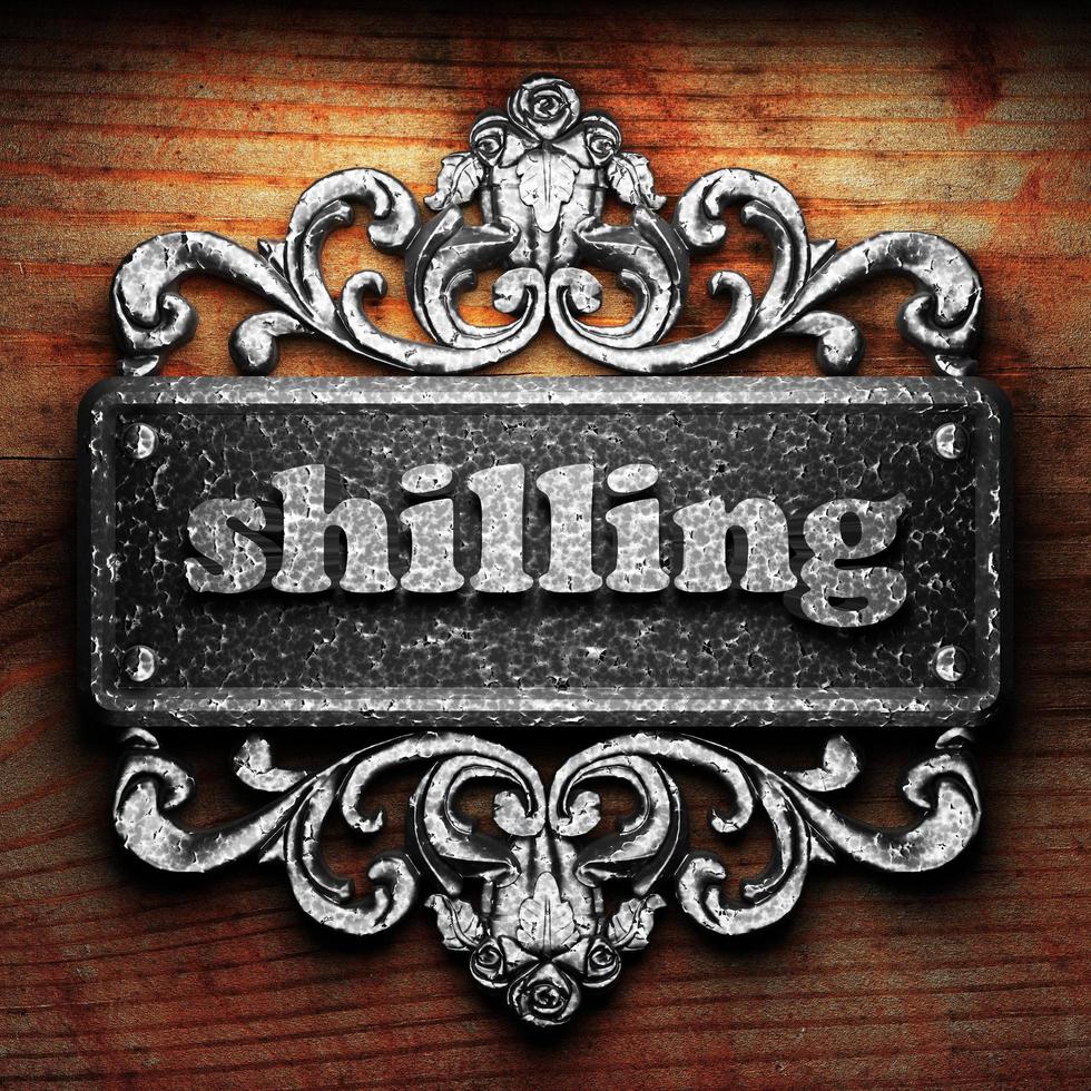 shilling word of iron on wooden background photo