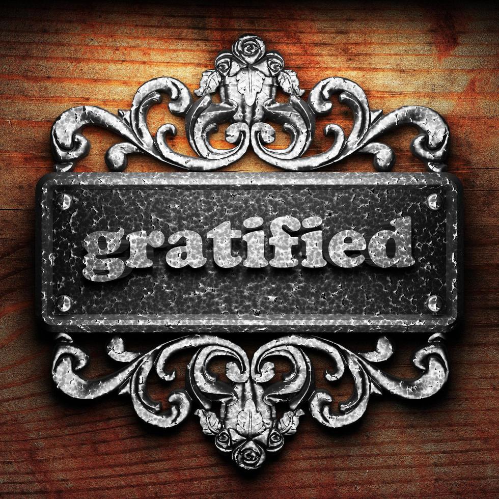 gratified word of iron on wooden background photo