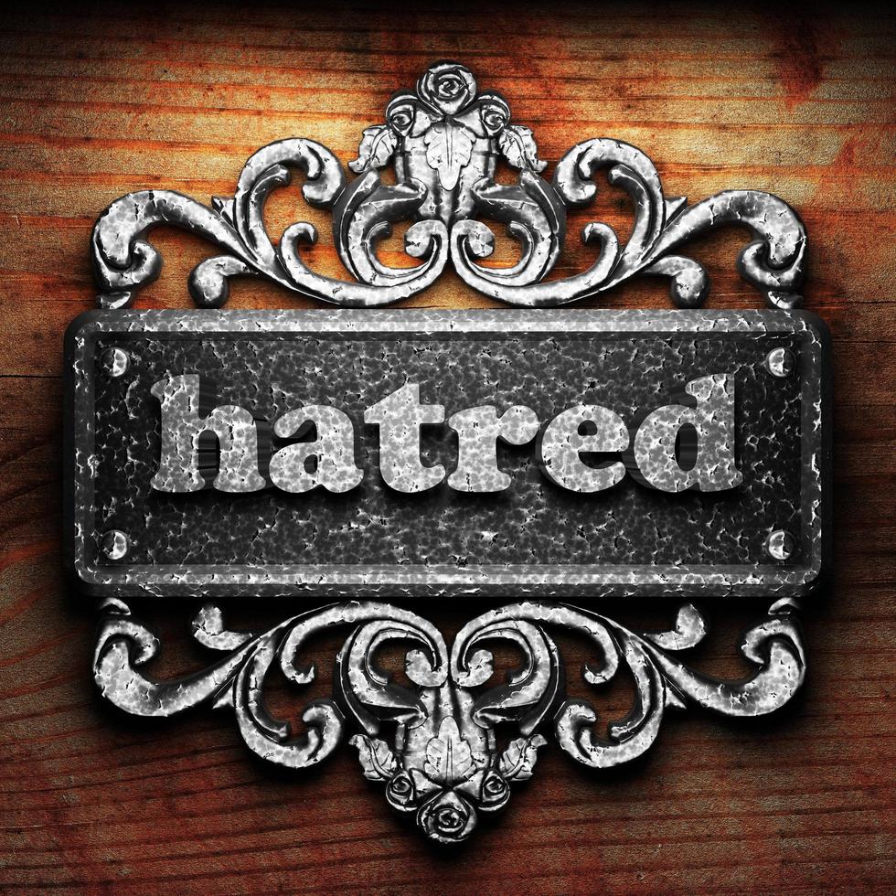 hatred word of iron on wooden background photo