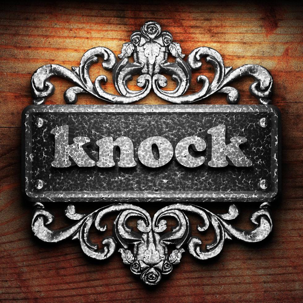 knock word of iron on wooden background photo