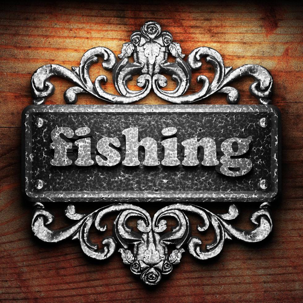 fishing word of iron on wooden background photo