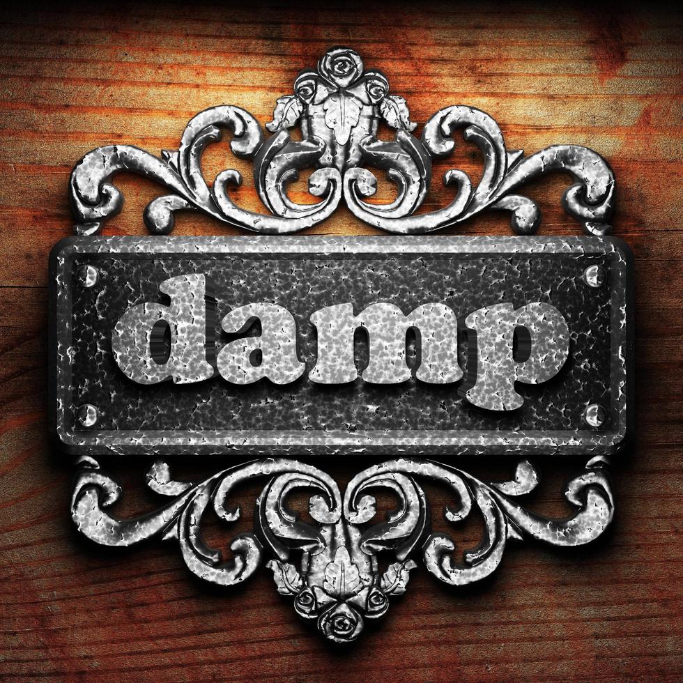 damp word of iron on wooden background photo