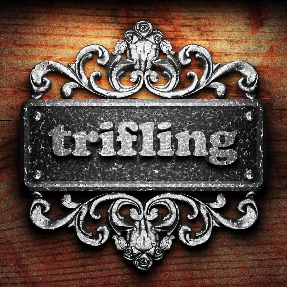 trifling word of iron on wooden background photo