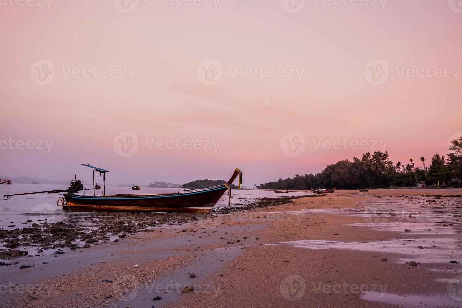 small fishing boat on the beach in the evening photo