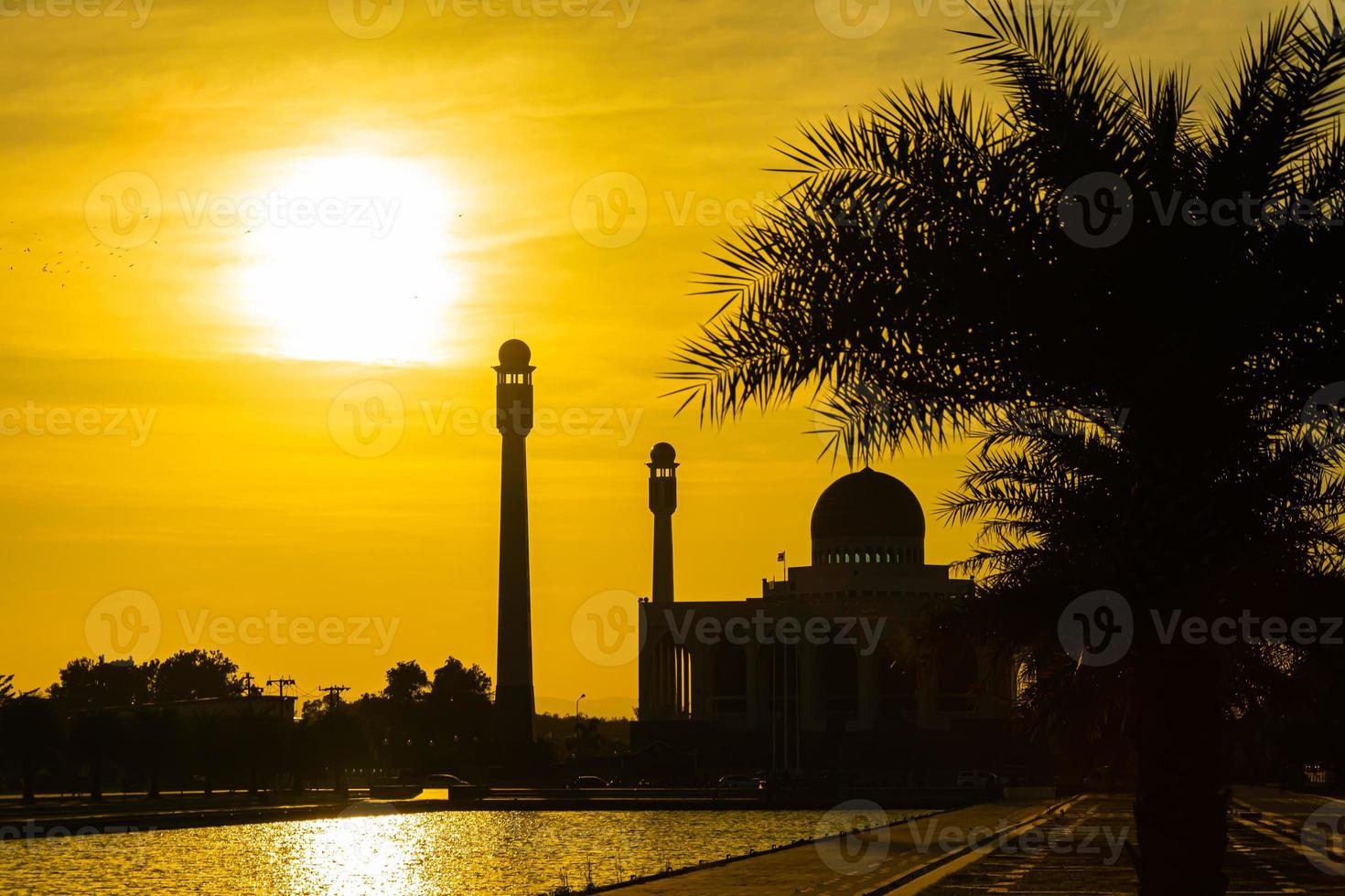 Songkhla Central Mosque in day to night with colorful skies at sunset and the lights of the mosque and reflections in the water in landmark landscape concept photo