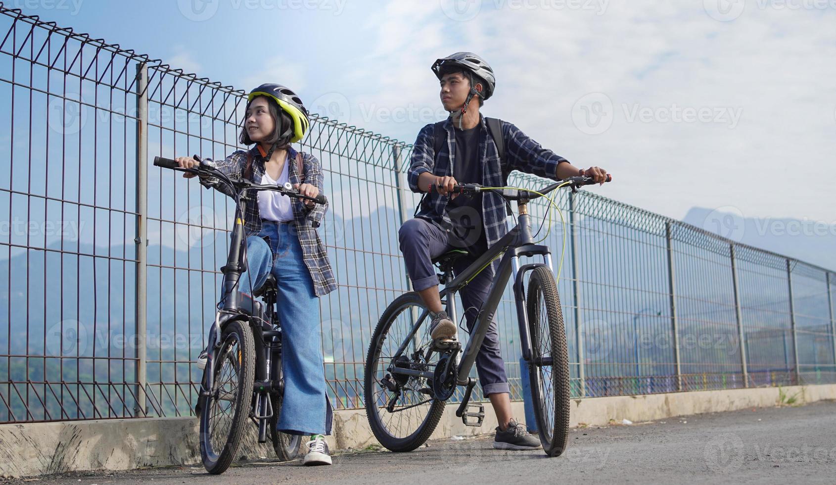 young asian couple having rest after ride bicycle go to work photo