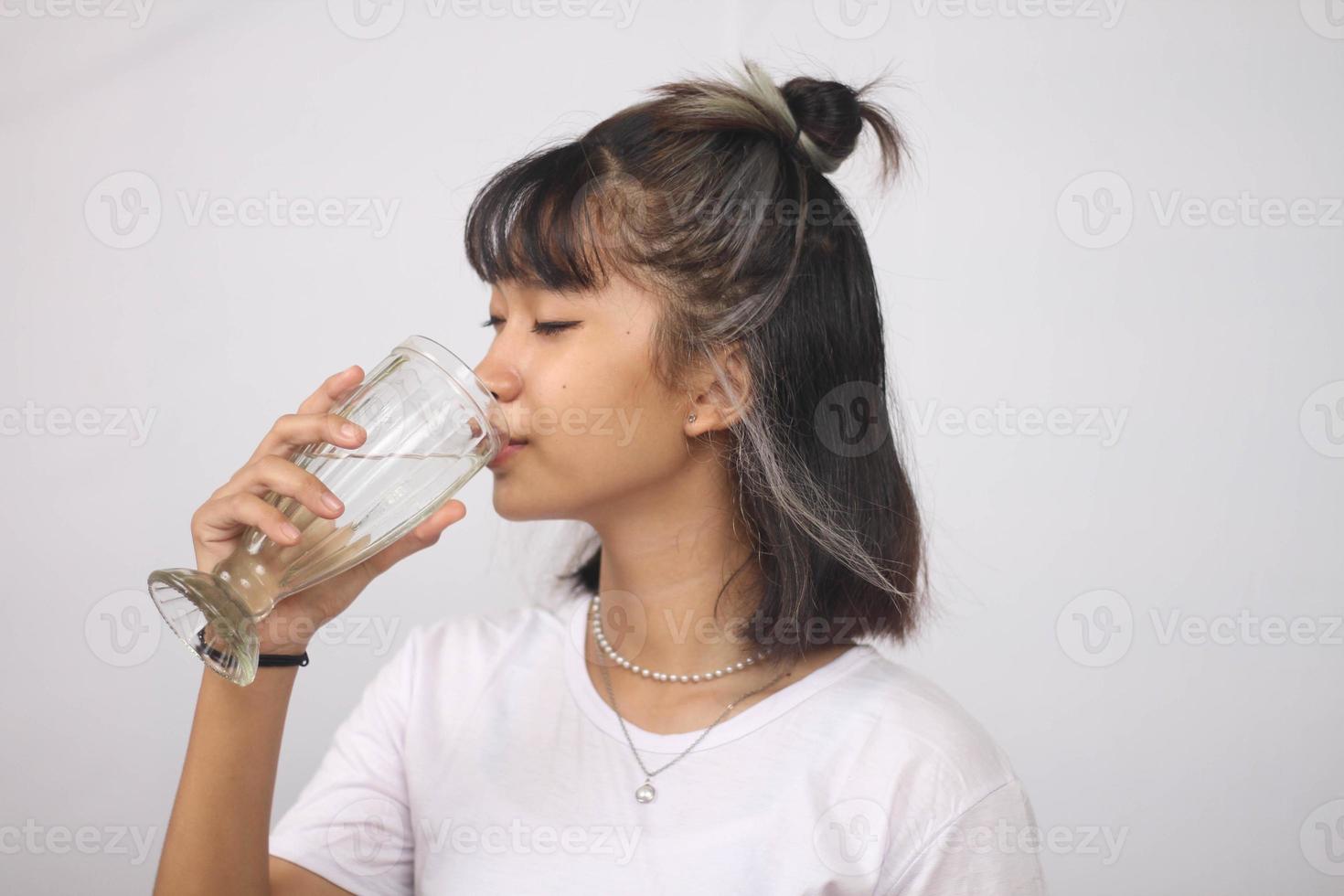 Asian woman drinking glass of water on white background isolated photo