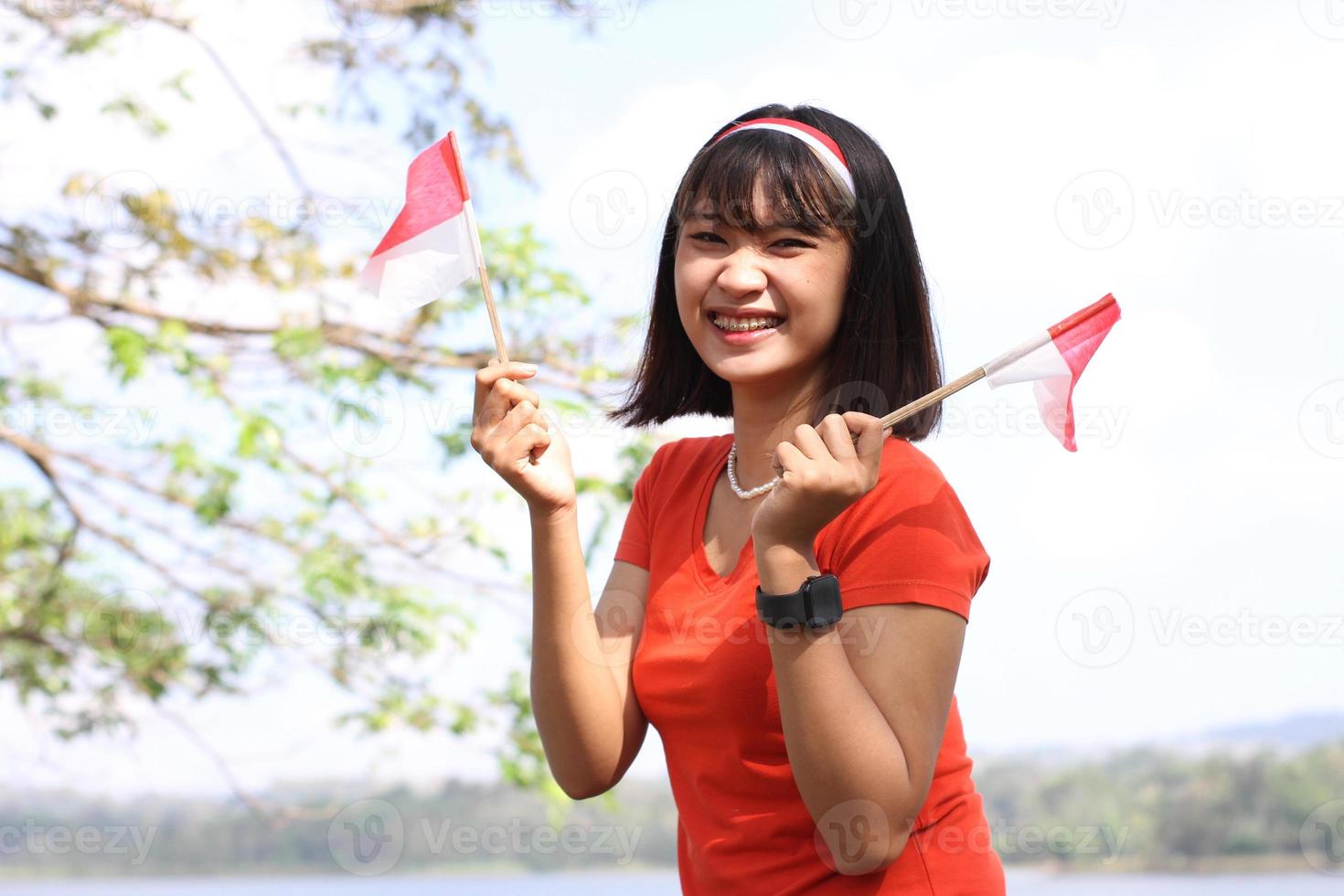 excited asian woman holding indonesian flag on indonesia independence day photo