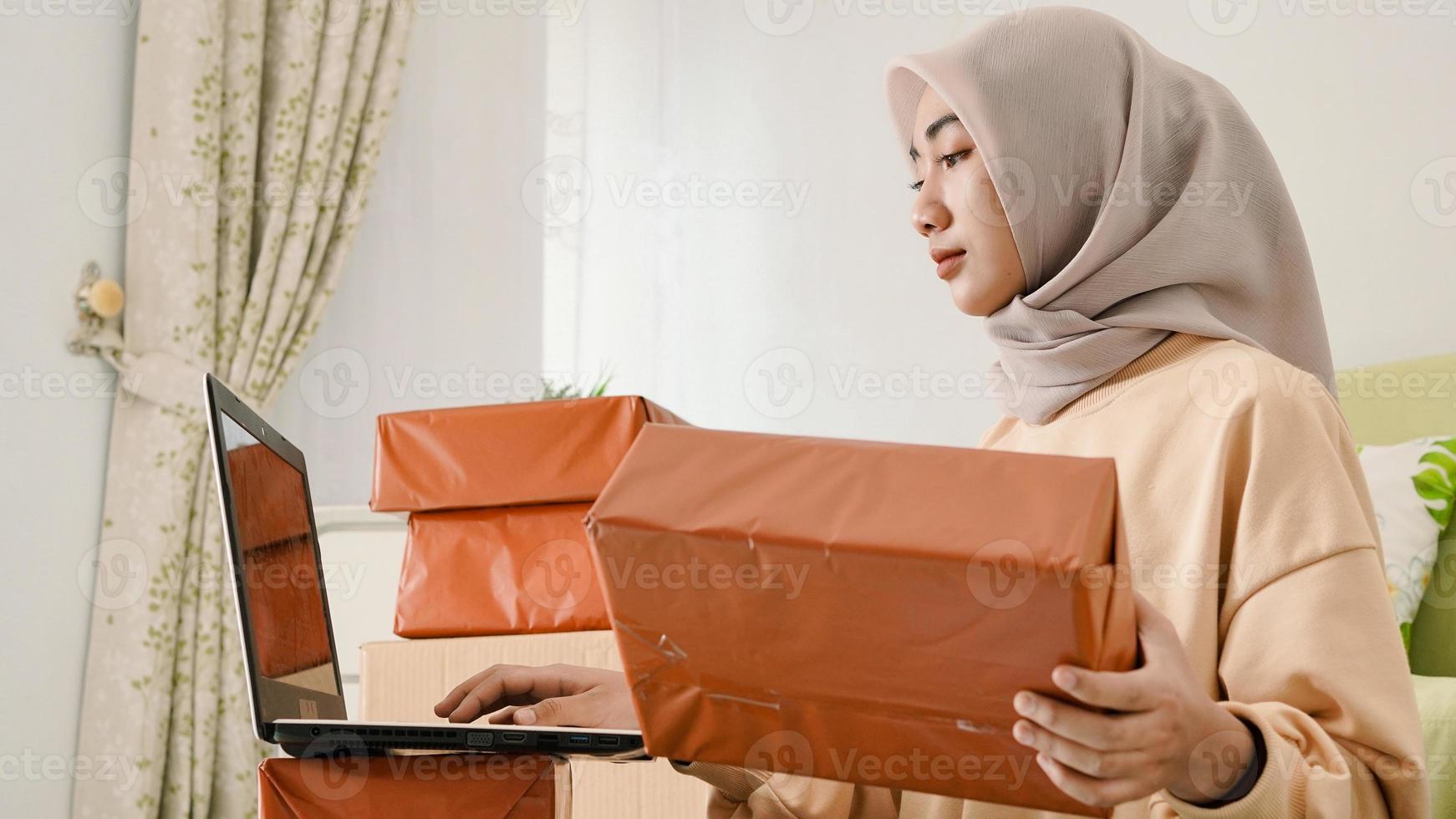 beautiful young asian businessman preparing orders to be packaged to customers photo