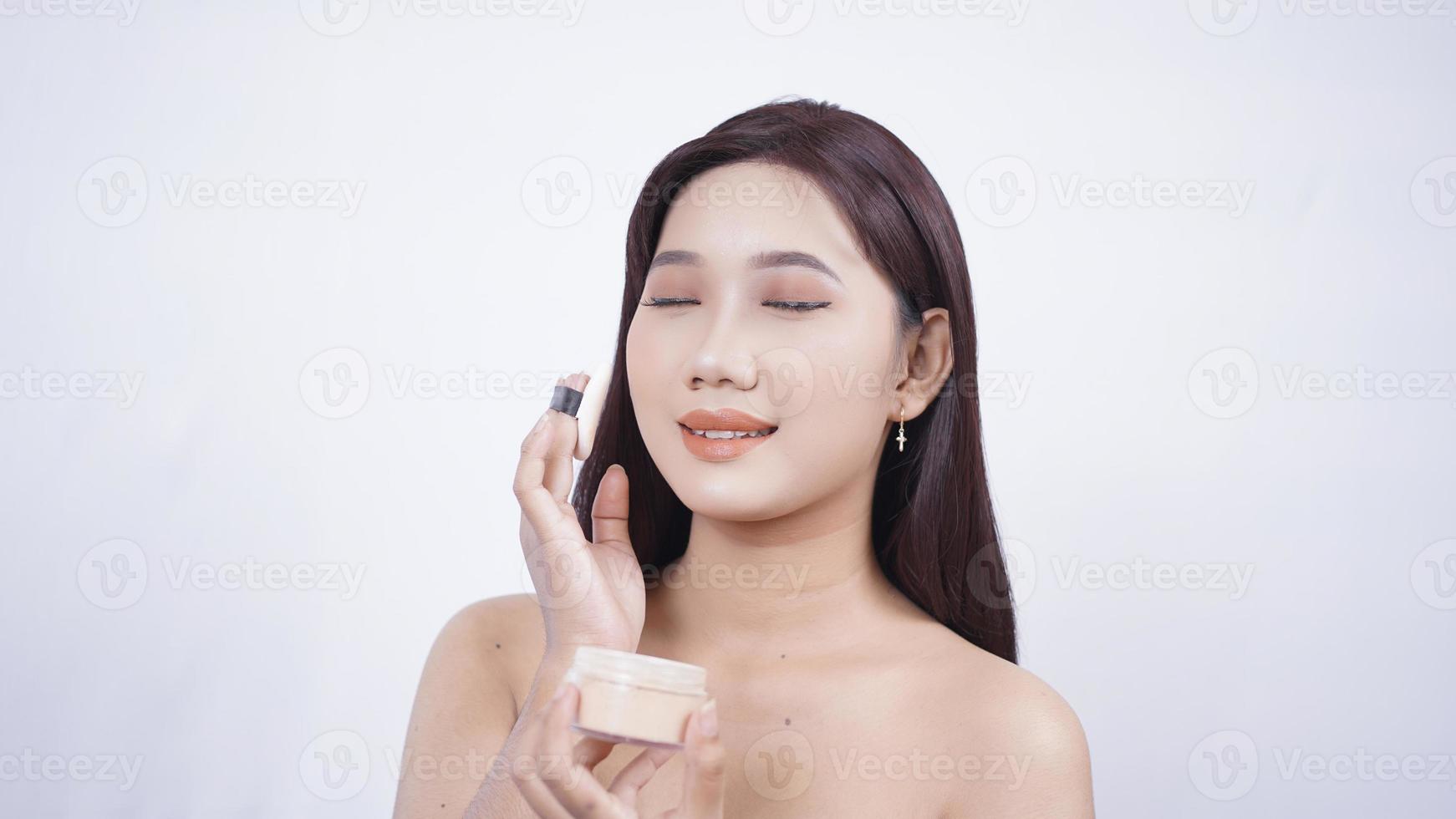 Asian beauty will apply powder isolated on white background photo