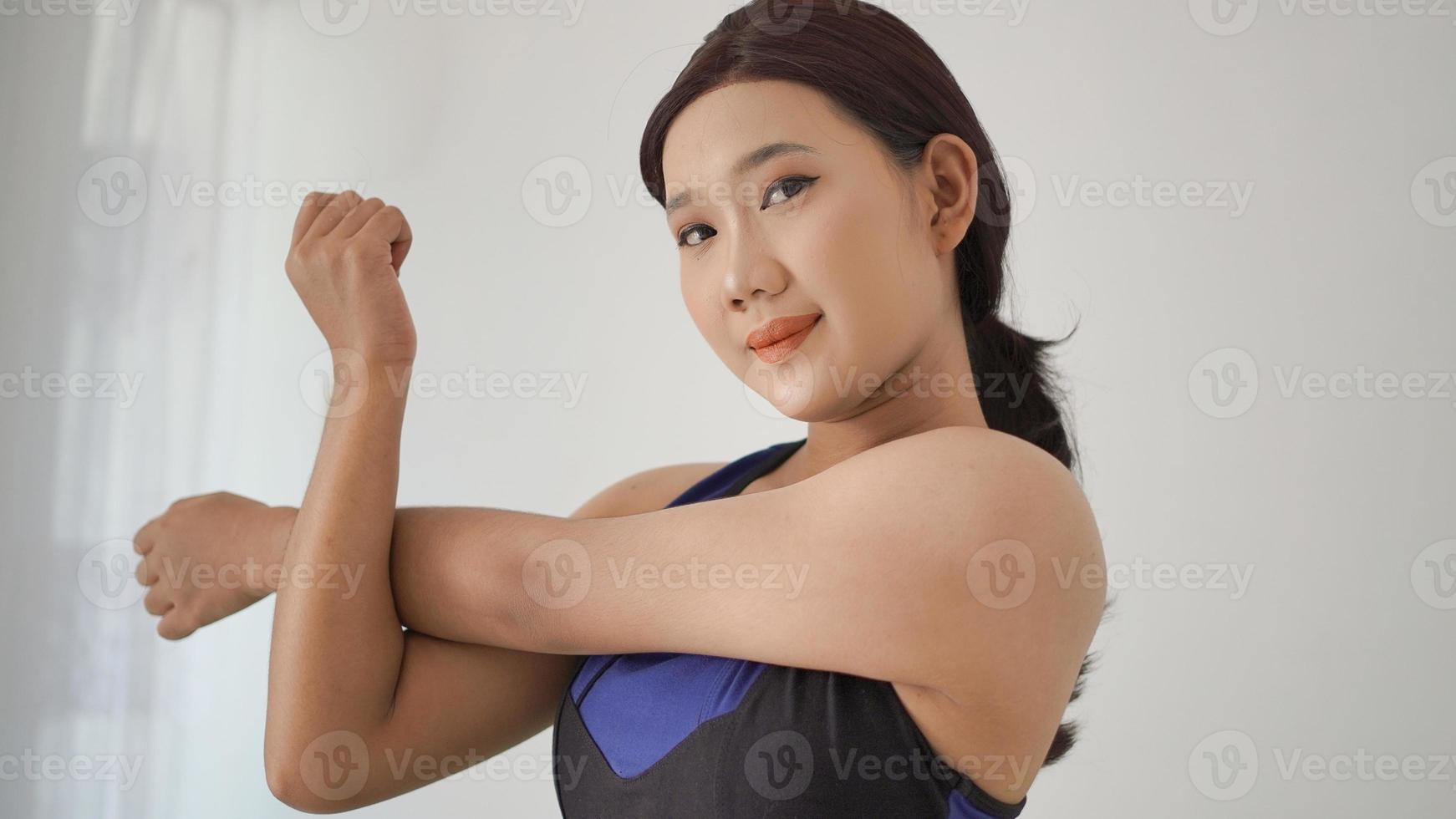 asian woman practicing yoga at home warming up hand gesture photo