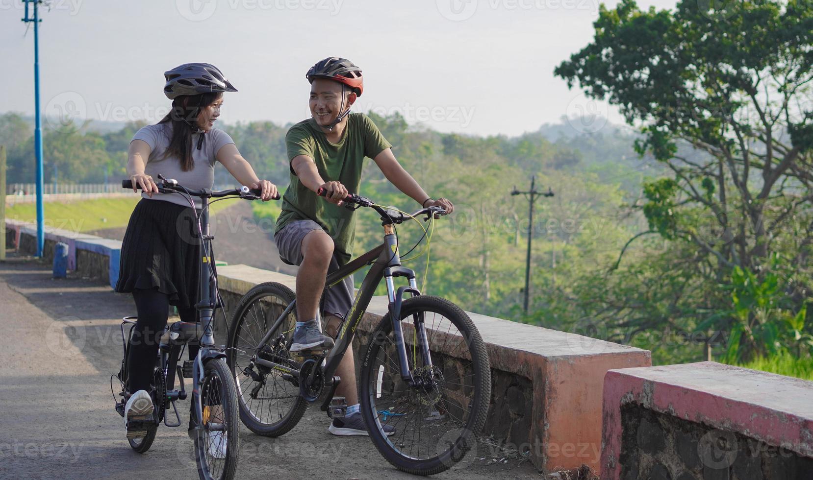 young asian couple having rest after ride bicycle photo
