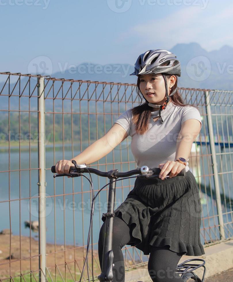 joven mujer asiática en bicicleta en verano foto