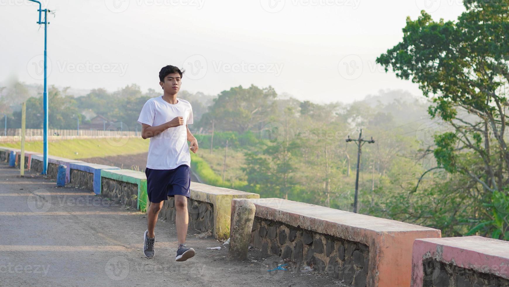 young asian man having jogging in the morning photo