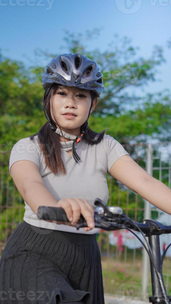 young asian woman enjoying cycling when stopped in summer morning photo