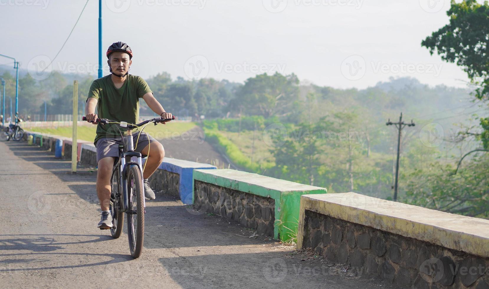 young asian man ride bicycle in the morning photo