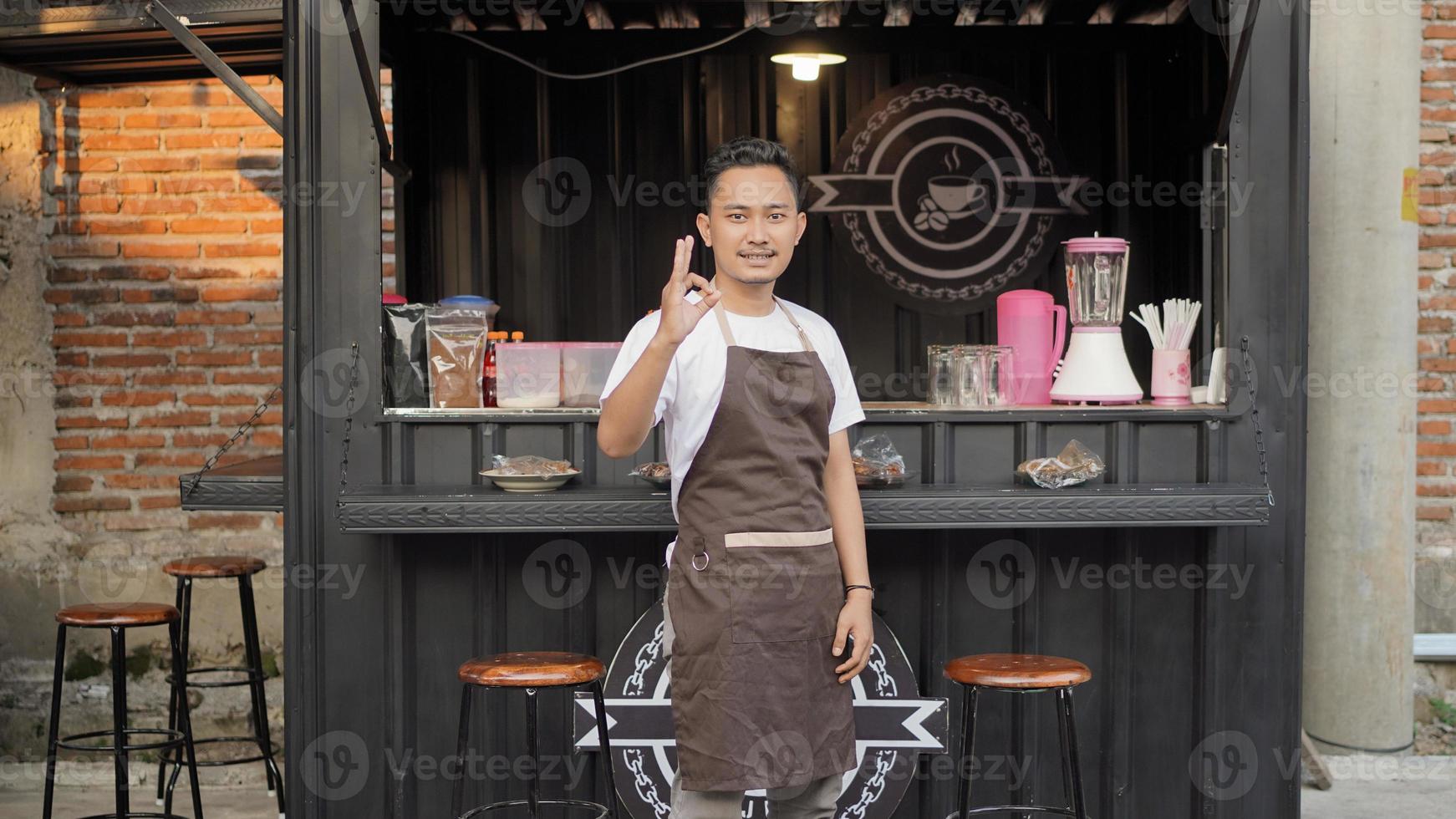 barista asiático gesticulando bien en un café temático de contenedores foto