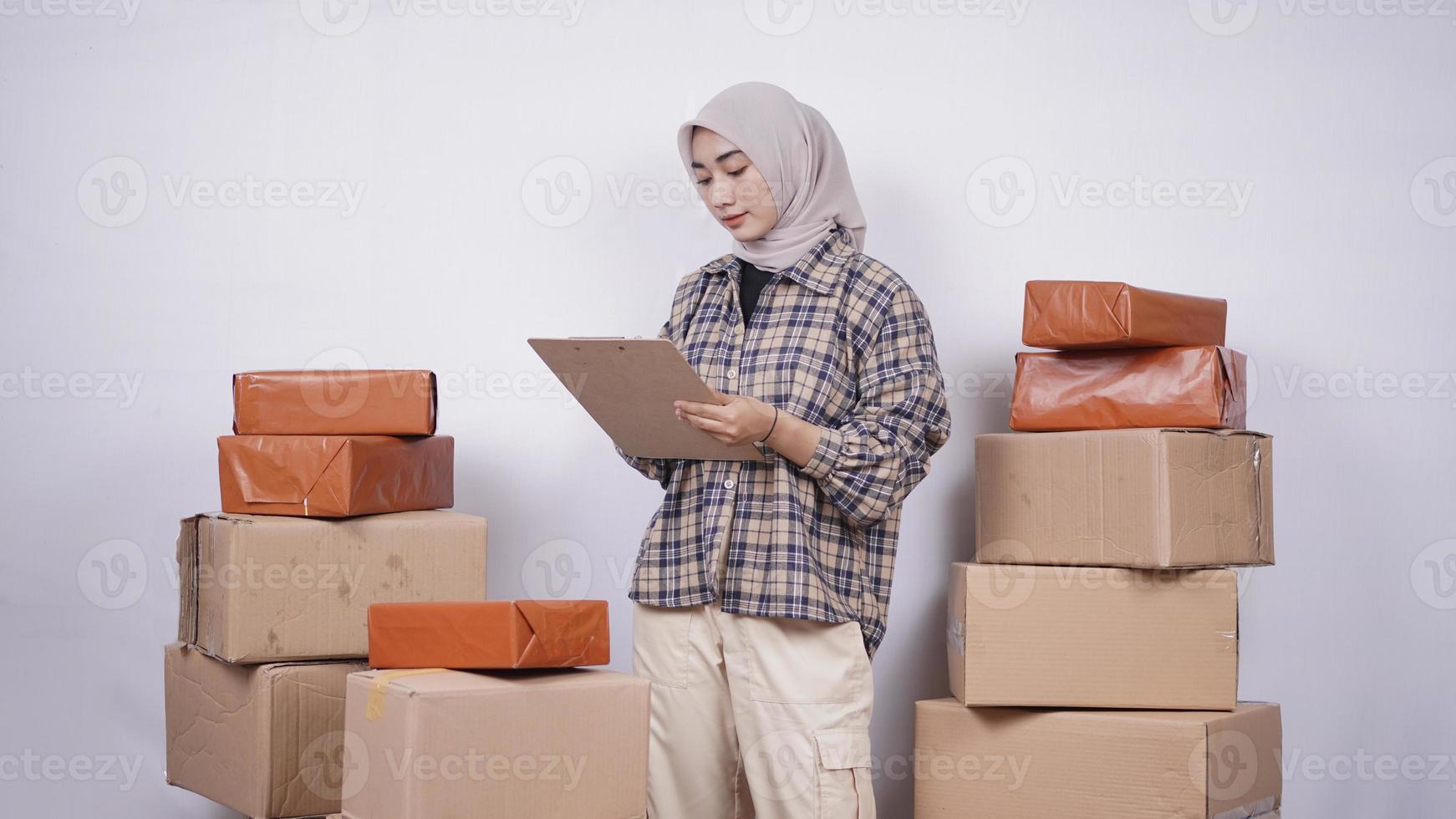 hermosa mujer de negocios revisando paquetes antes de que se envíen aislados en fondo blanco foto