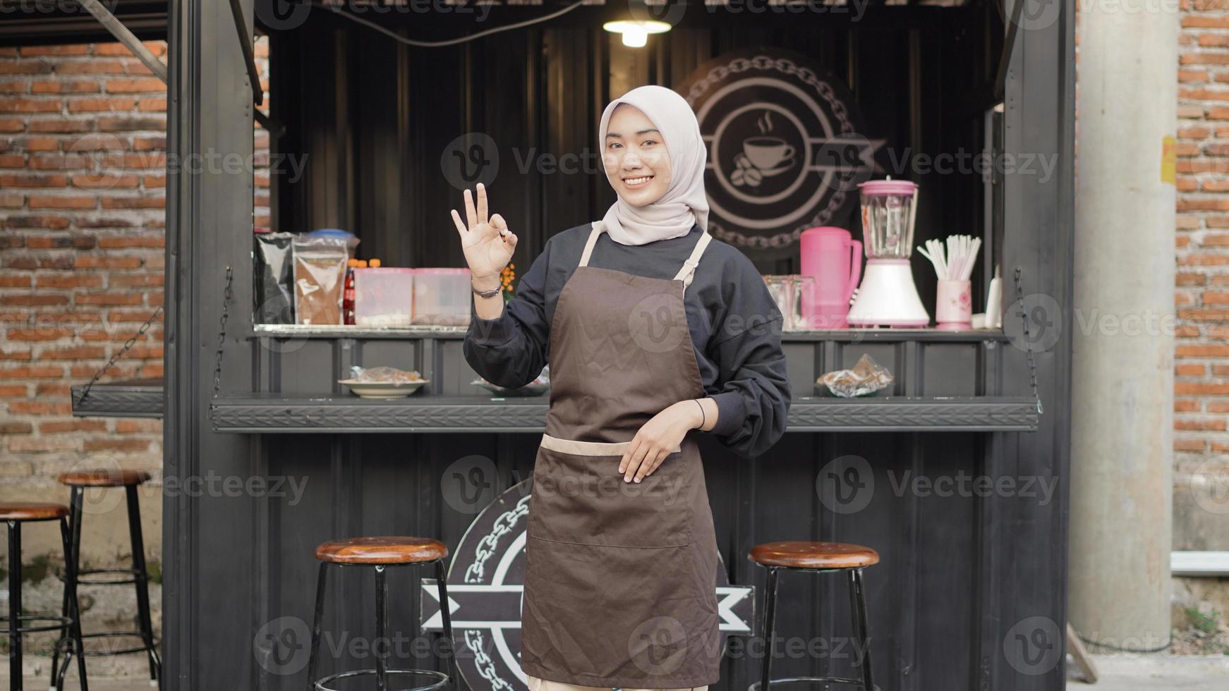 hermosa camarera sonriente lista para abrir el contenedor de la cabina del café foto