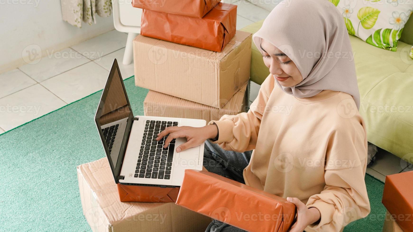 hermoso joven empresario asiático preparando pedidos para ser empaquetados a los clientes foto