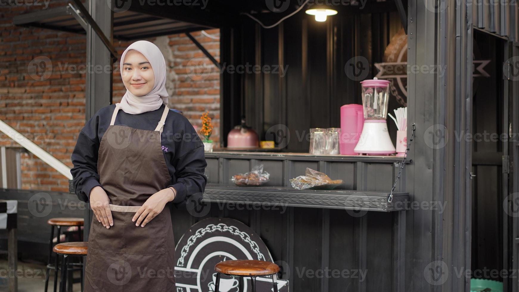 Beautiful smiling barista ready to open cafe booth container photo