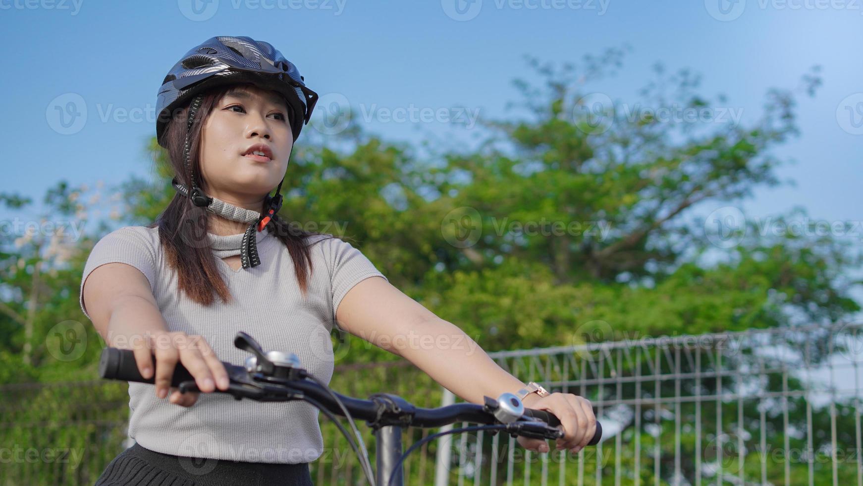 young asian woman enjoying cycling in summer morning photo