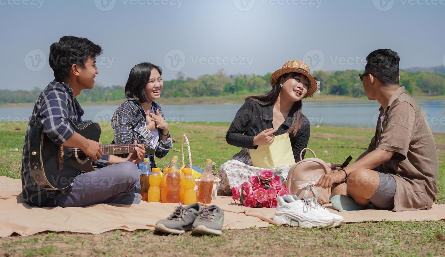 Young people talking and laughing together while having a vacation in the park photo