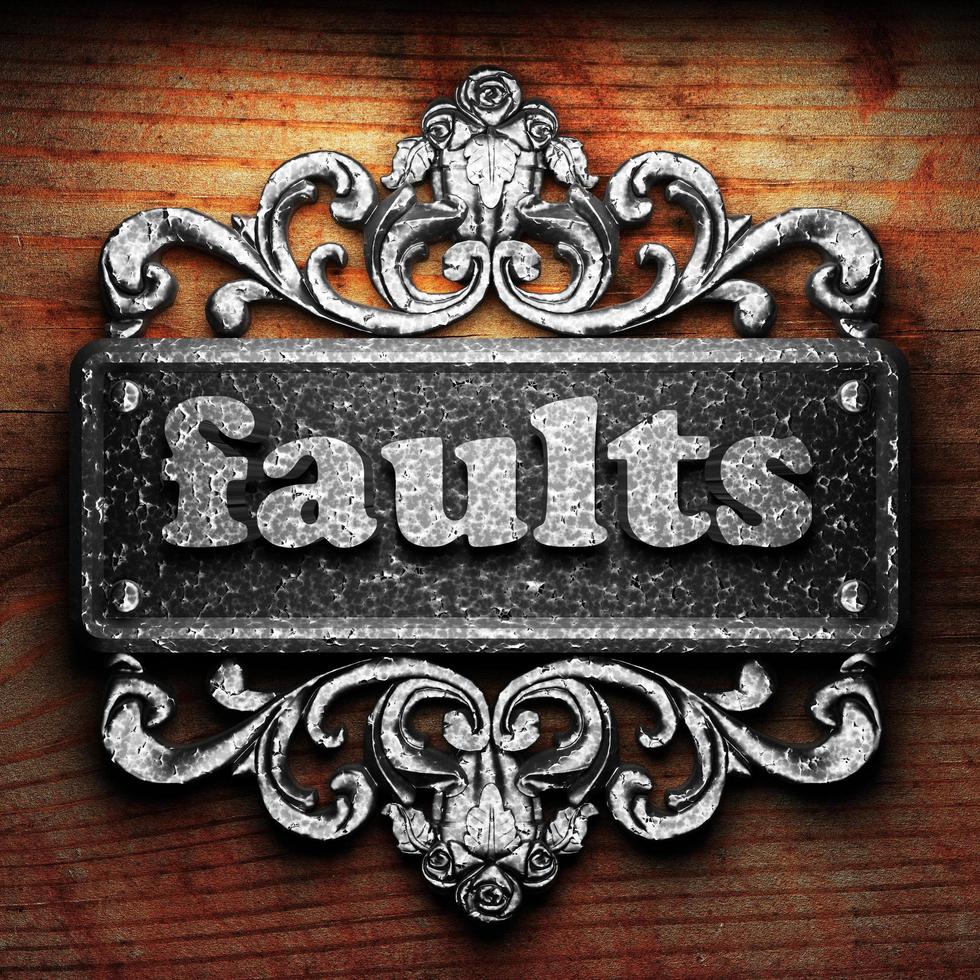 faults word of iron on wooden background photo
