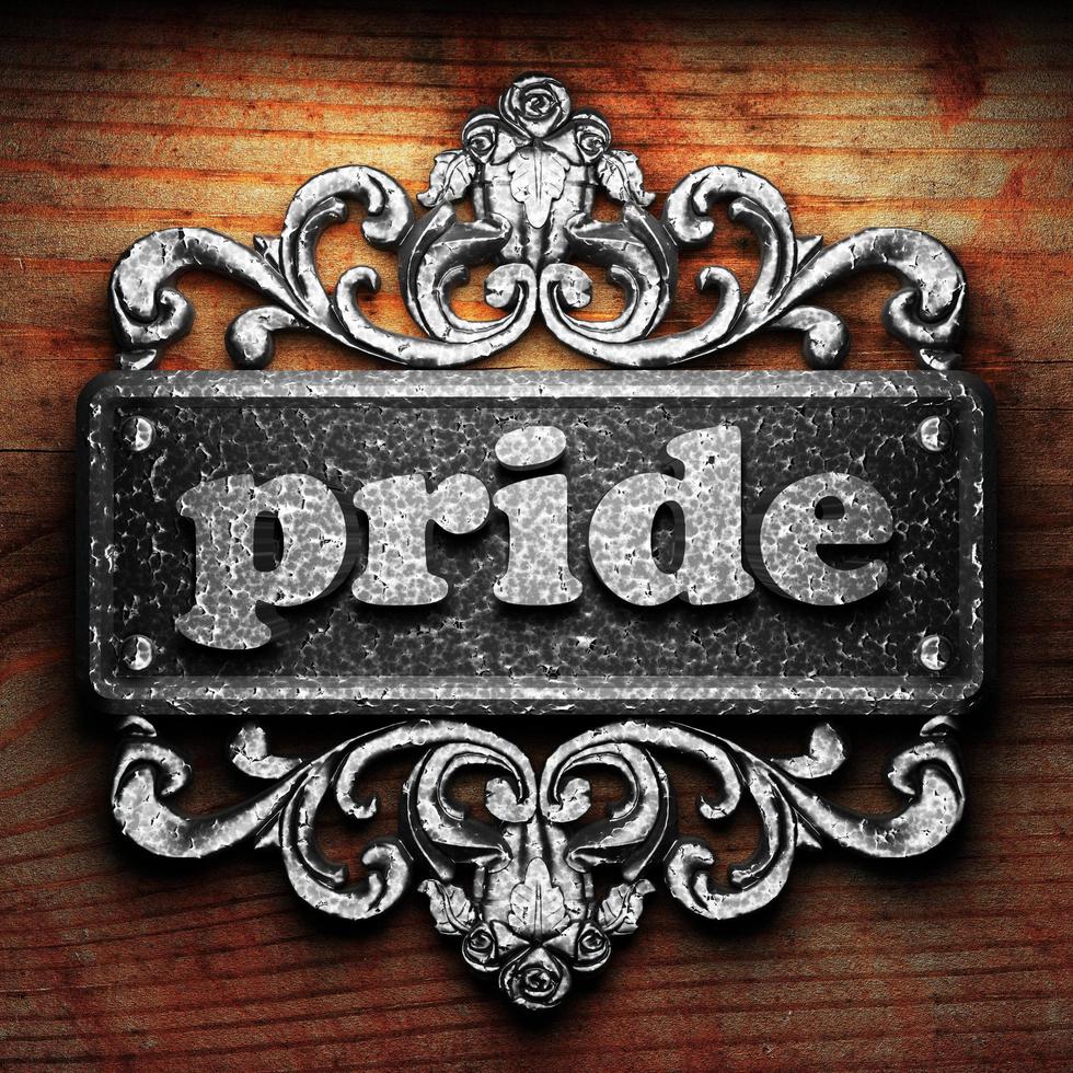 pride word of iron on wooden background photo