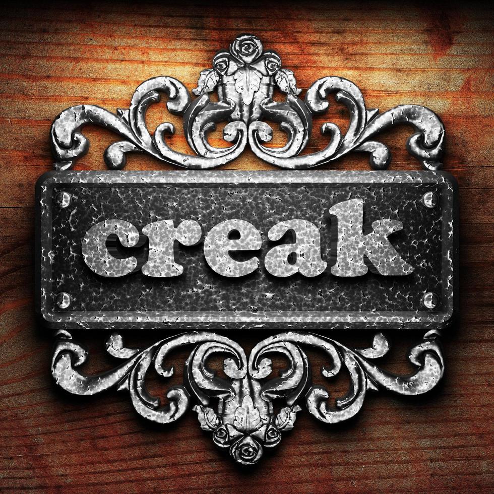 creak word of iron on wooden background photo