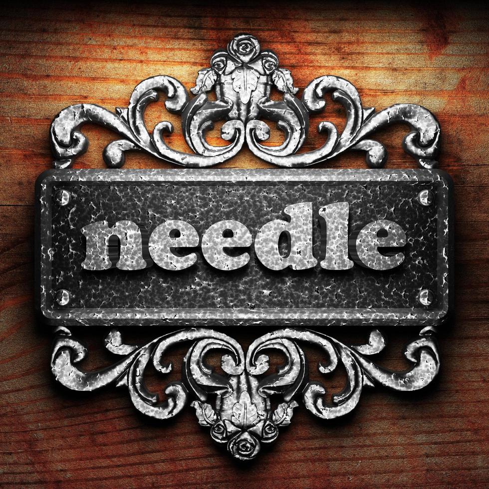needle word of iron on wooden background photo