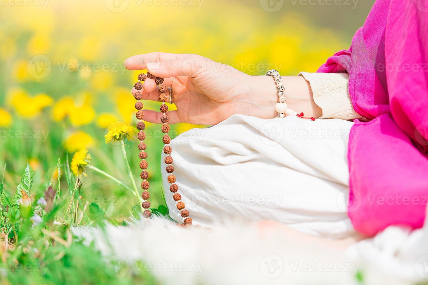 Woman reads the yoga mantra during practice with the mala photo