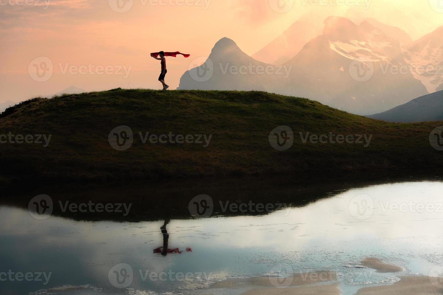 Girl runs in the mountains with a scarf in hand at sunset photo
