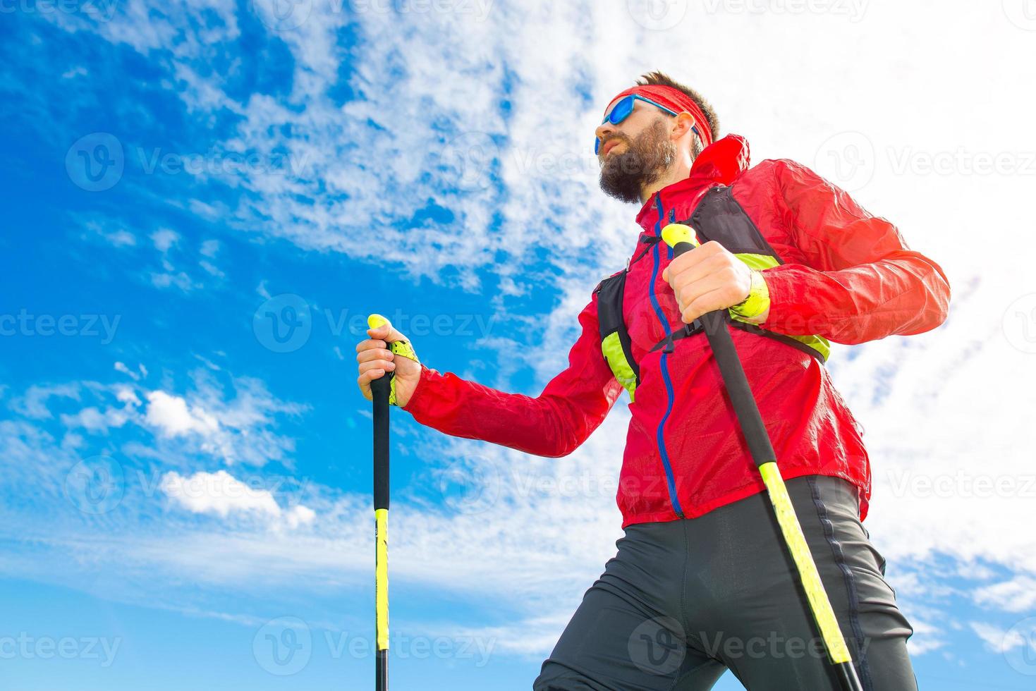 hombre con palos entre marcha nórdica con fondo de cielo foto