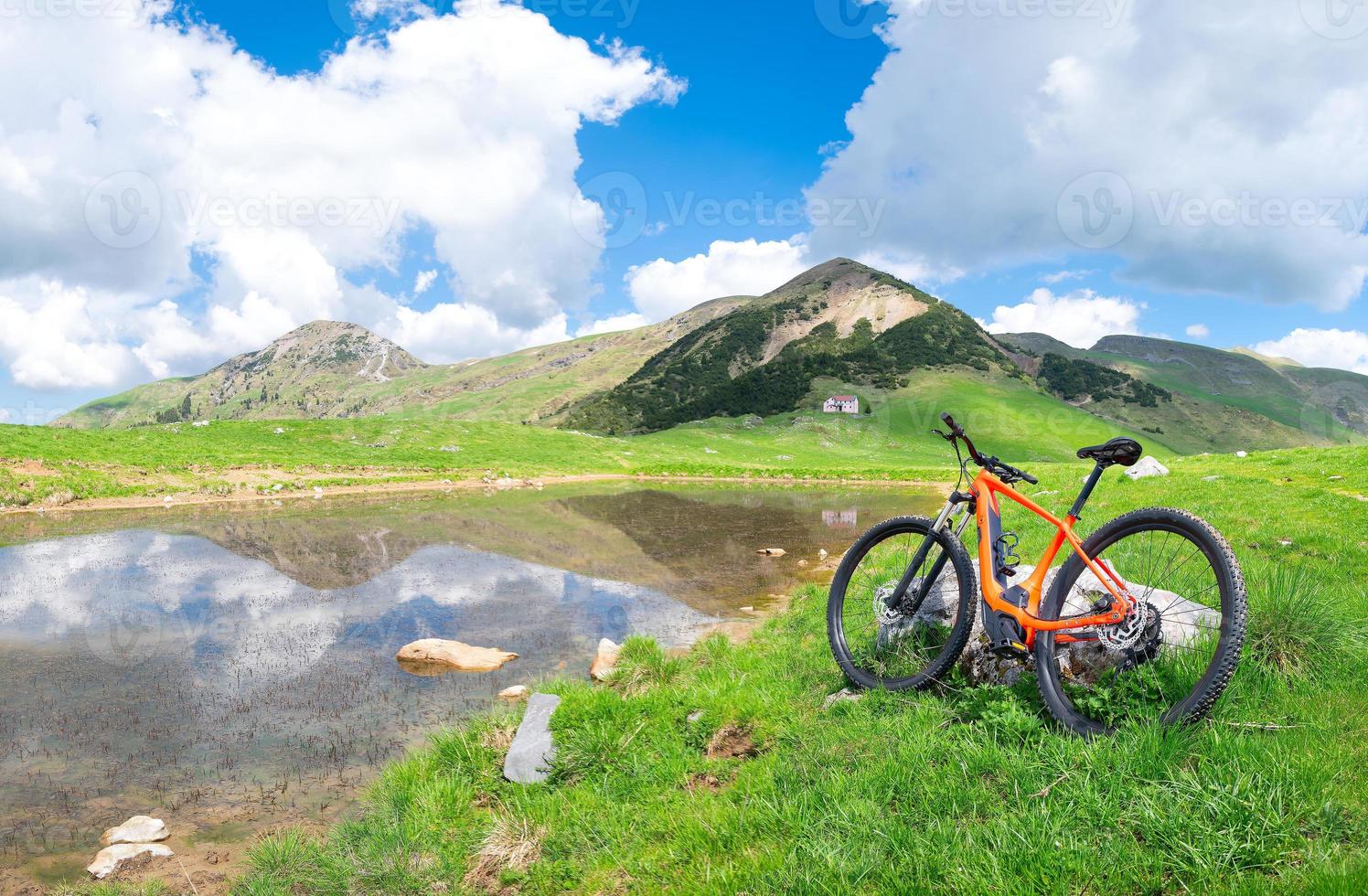 Mountain ebike stops near an alpine lake in spring photo