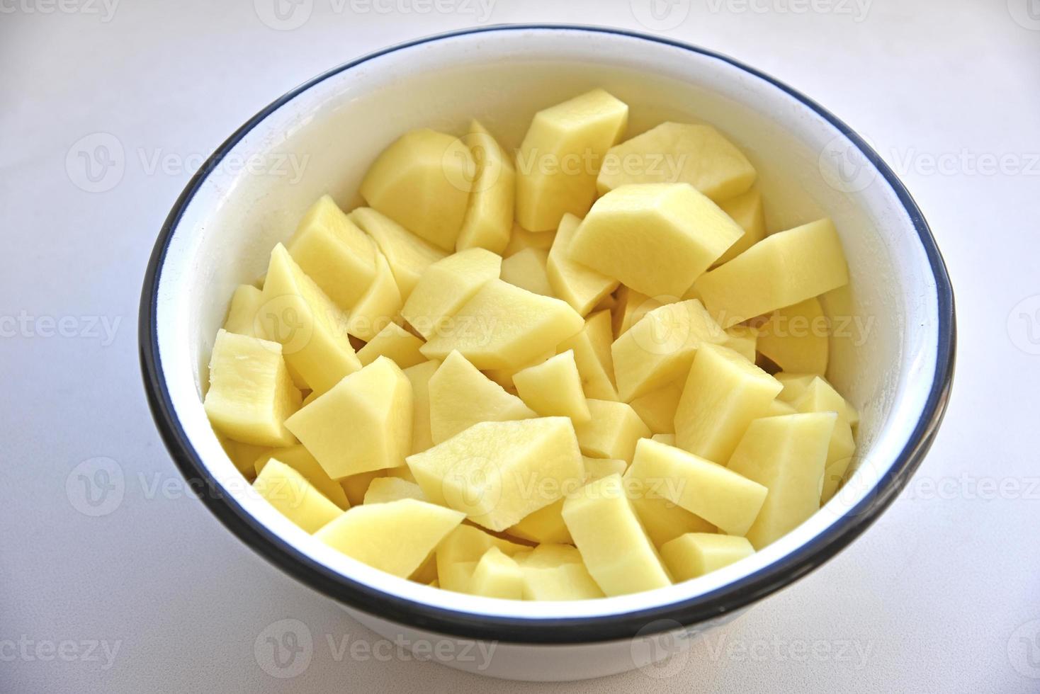 patatas peladas en tiras en una cacerola blanca foto