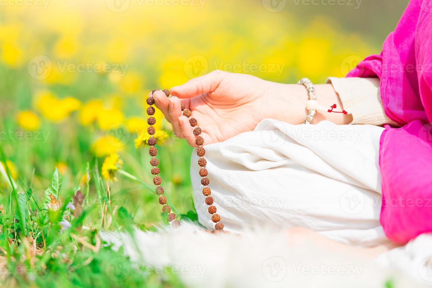 recitación de mantras sosteniendo el mala durante una práctica de yoga foto