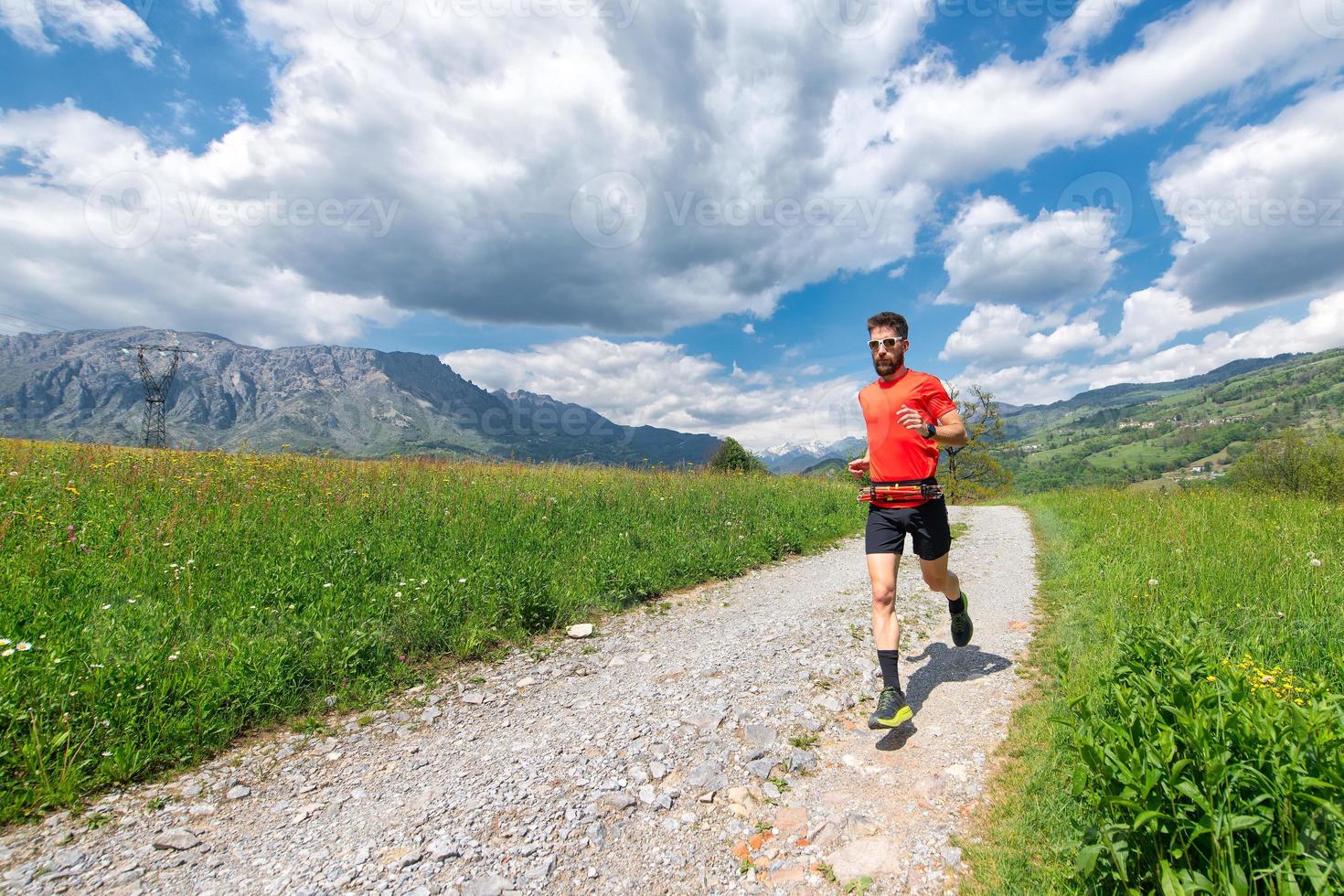 atleta ultra trail runner se prepara en un camino de tierra foto