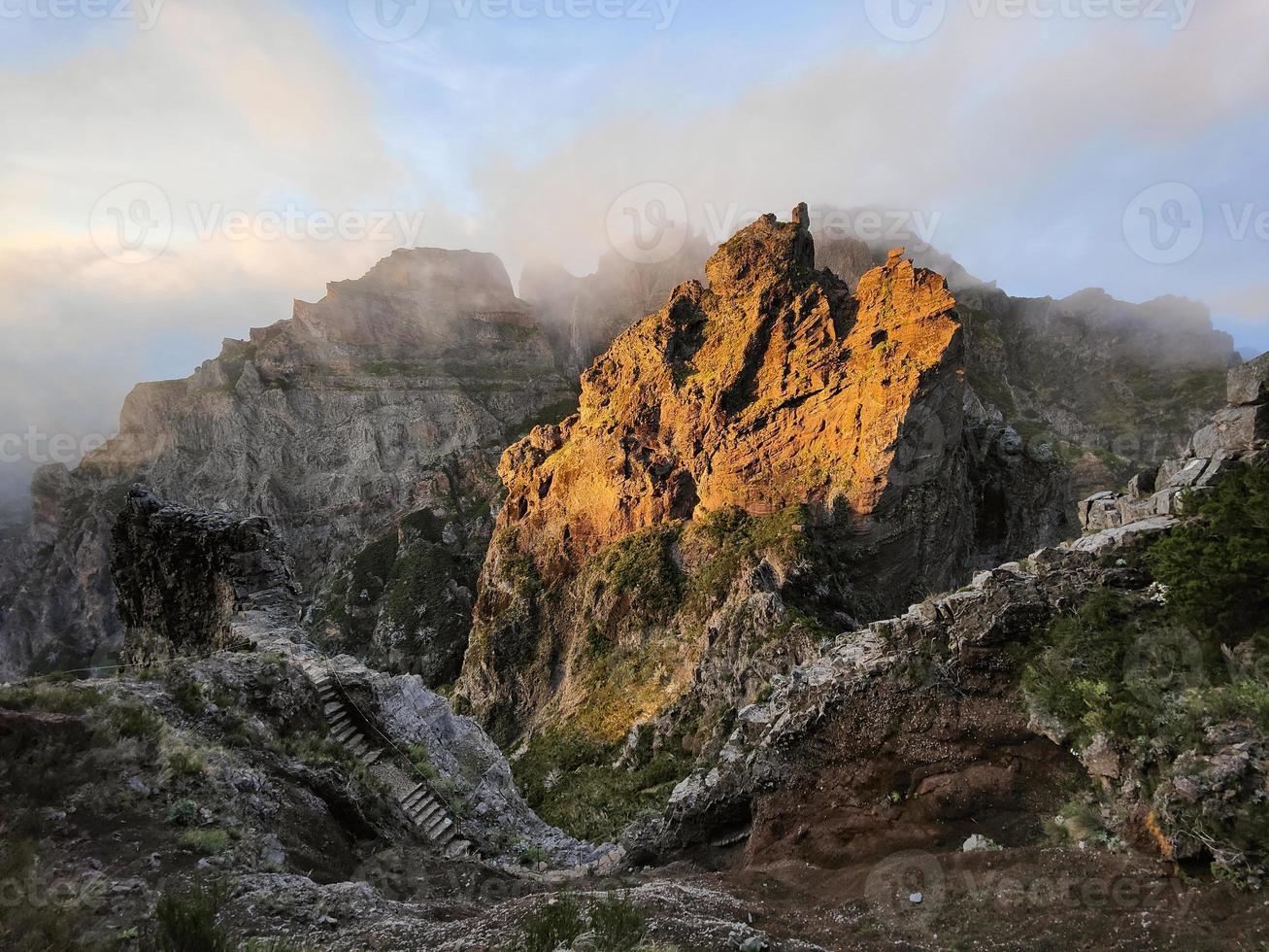 Amazing, sunset over a pyramid shaped mountain peak.  Beautiful golden orange sunlight. Travel the world. Nomad life. Adventurous lifestyle. Holidays. Hiking in Madeira Island, Portugal. photo