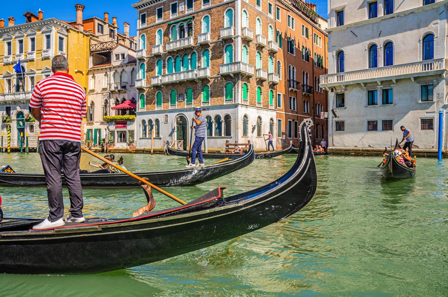 venecia, italia, 13 de septiembre de 2019 gondolero y turistas en góndola barco tradicional navegando en el agua del gran canal en venecia foto