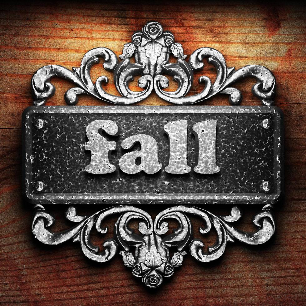 fall word of iron on wooden background photo