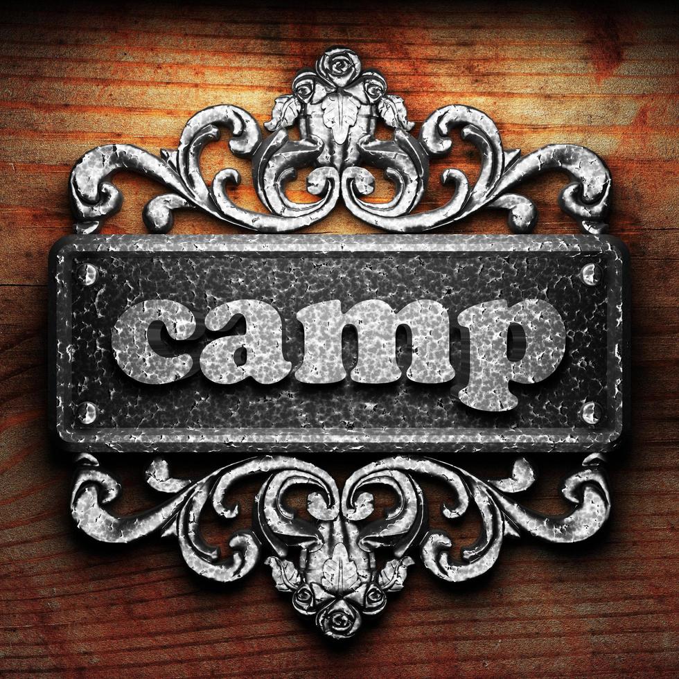 camp word of iron on wooden background photo