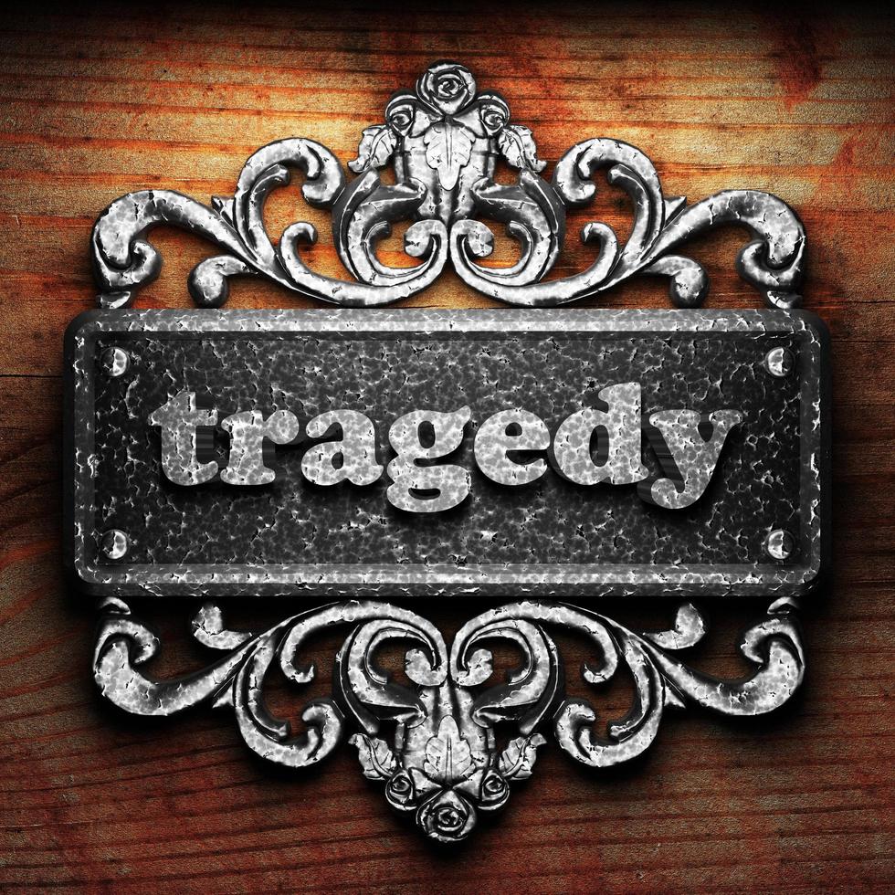 tragedy word of iron on wooden background photo