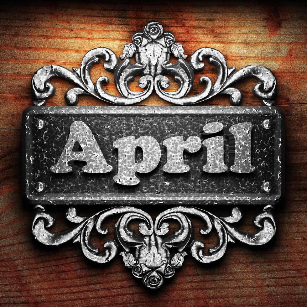April word of iron on wooden background photo