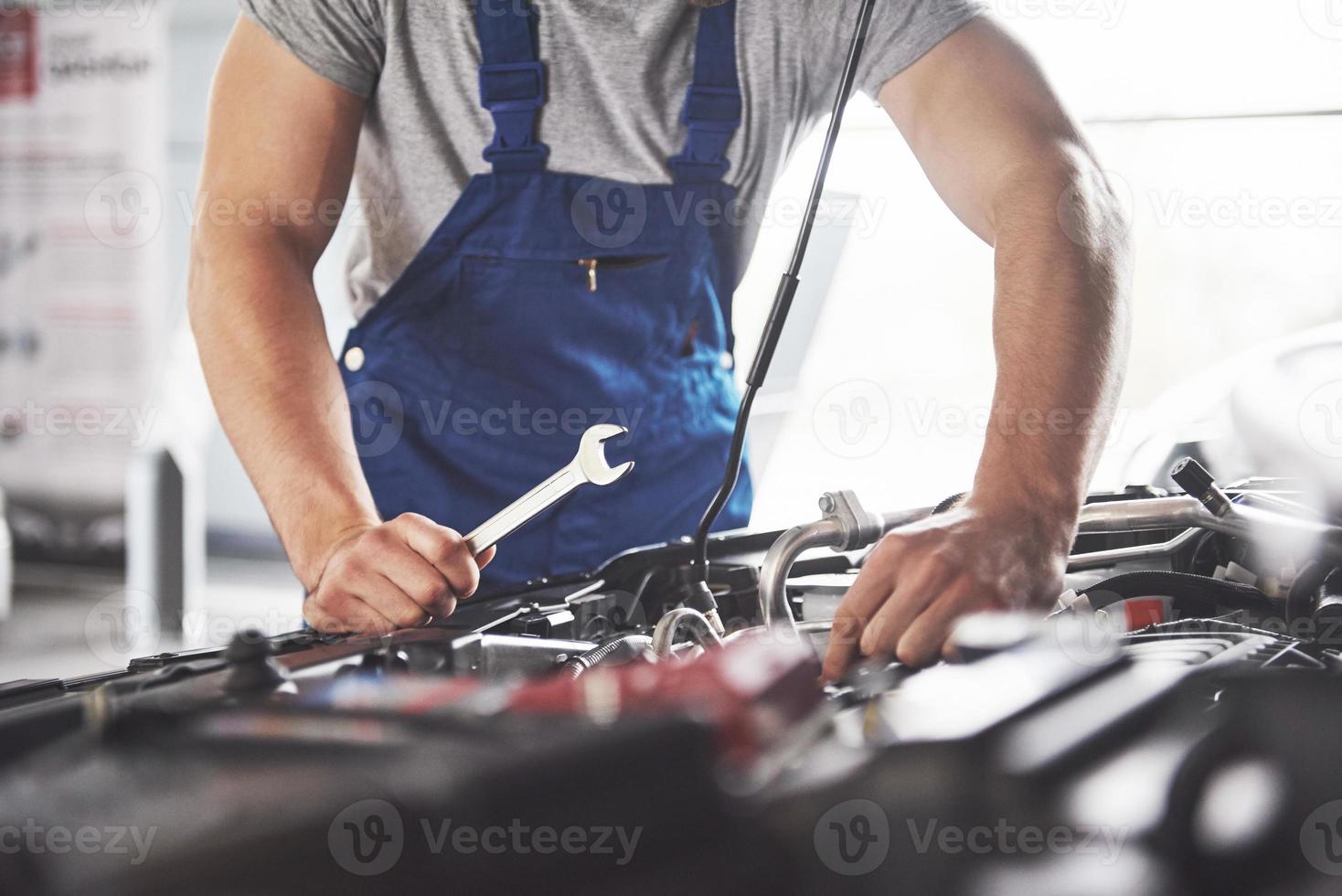 Picture showing muscular car service worker repairing vehicle photo