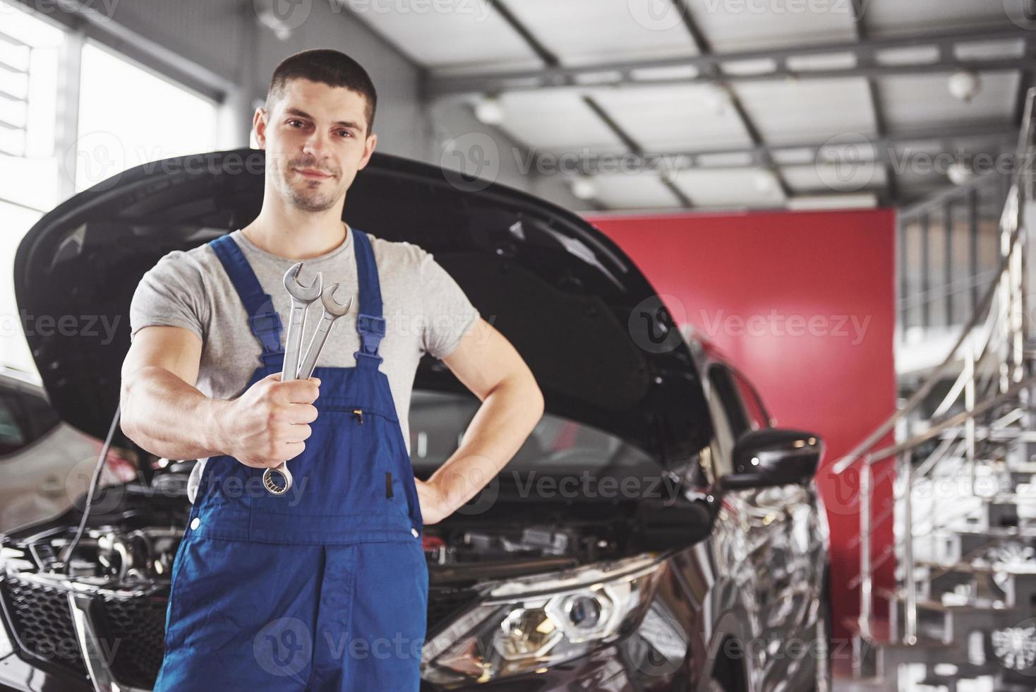 Hands of car mechanic with wrench in garage photo