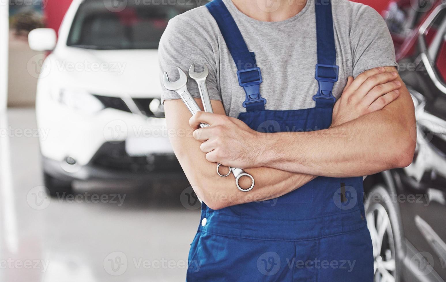 Hand of car mechanic with wrench. Auto repair garage photo