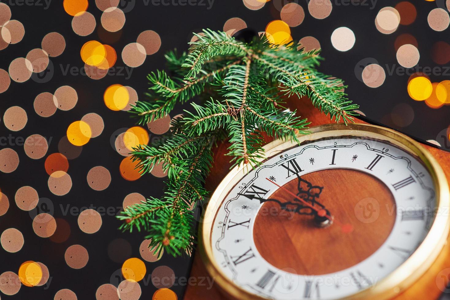 feliz año nuevo a la medianoche de 2018, viejo reloj de madera con luces navideñas y ramas de abeto foto